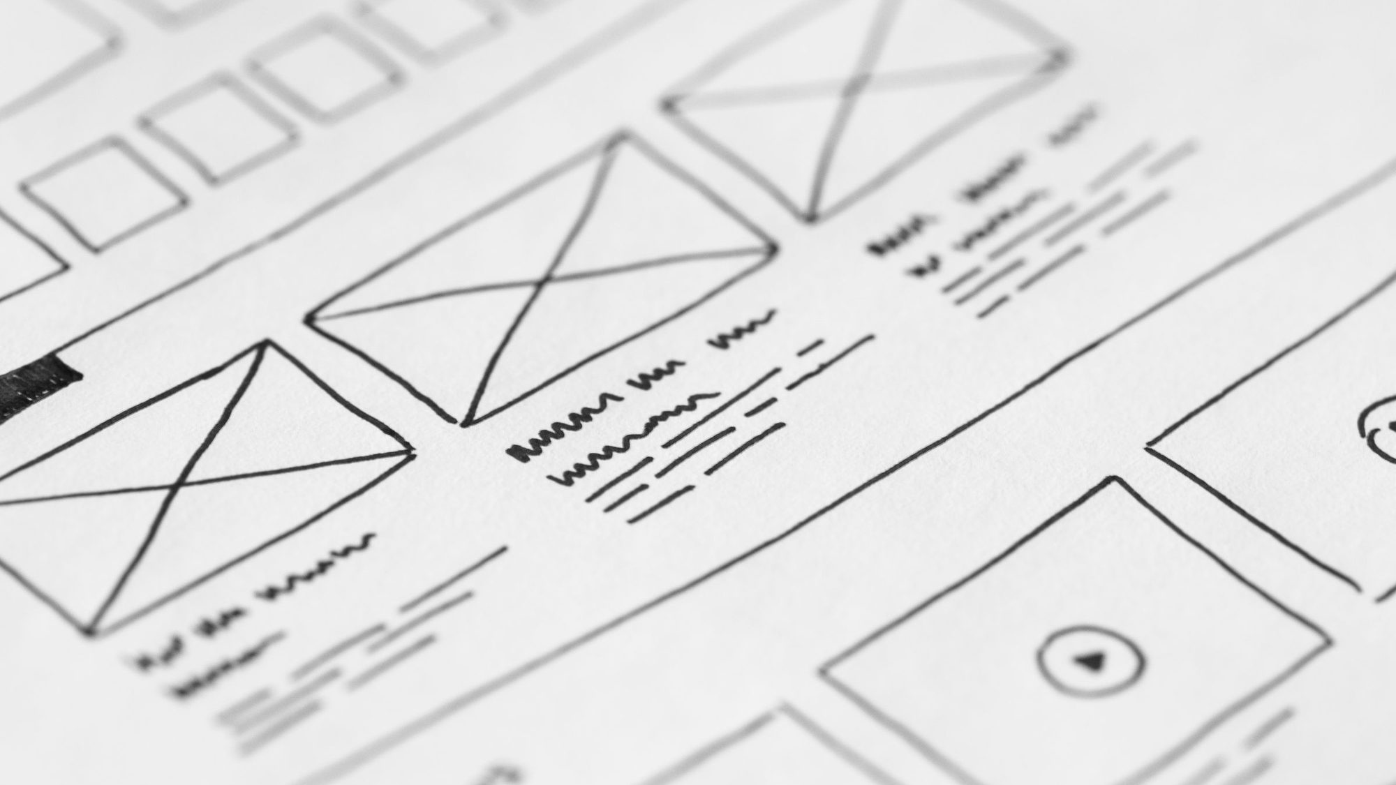 A hand drawn website wireframe sketched on paper