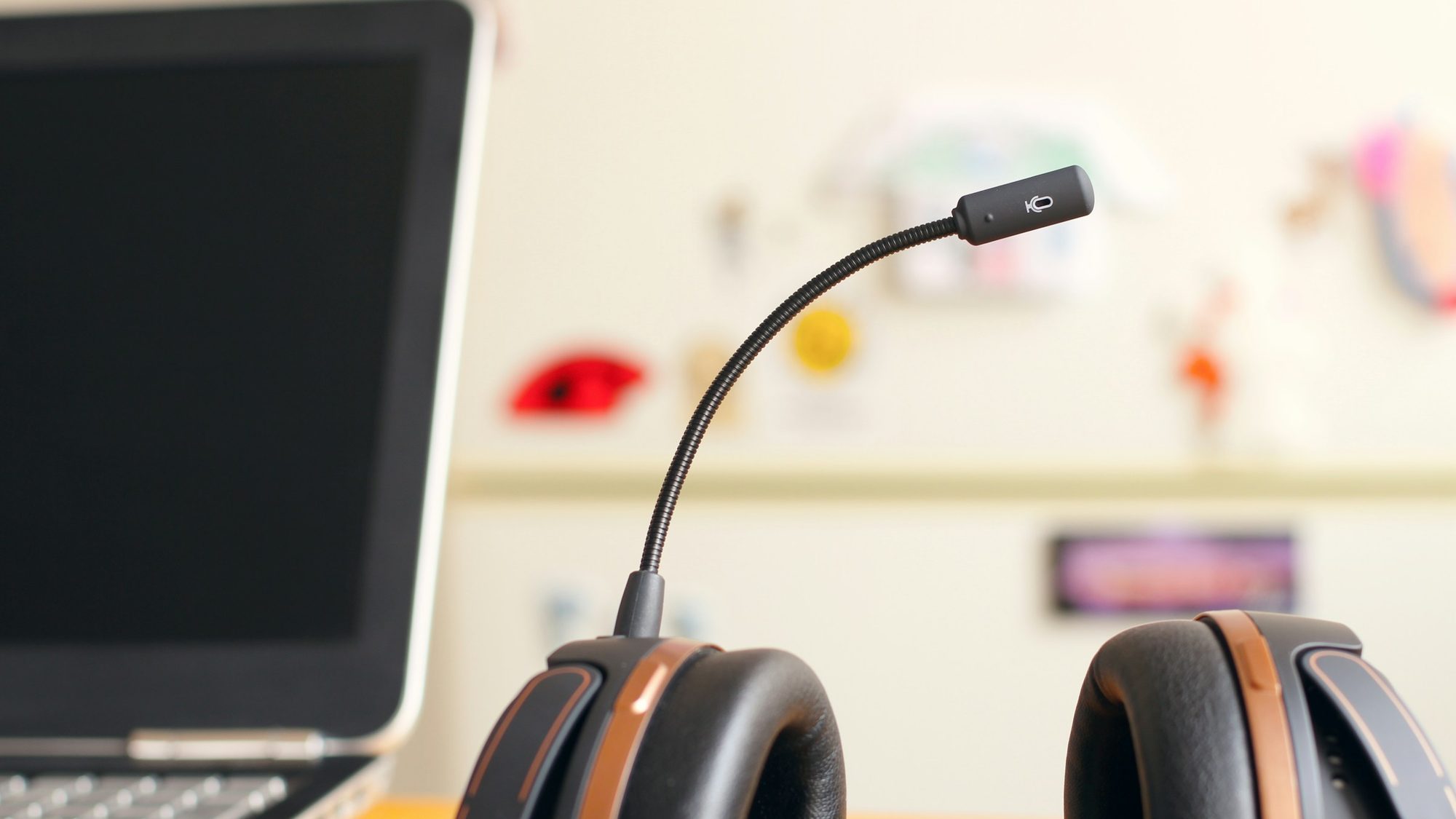 A headset with a microphone resting next to a laptop