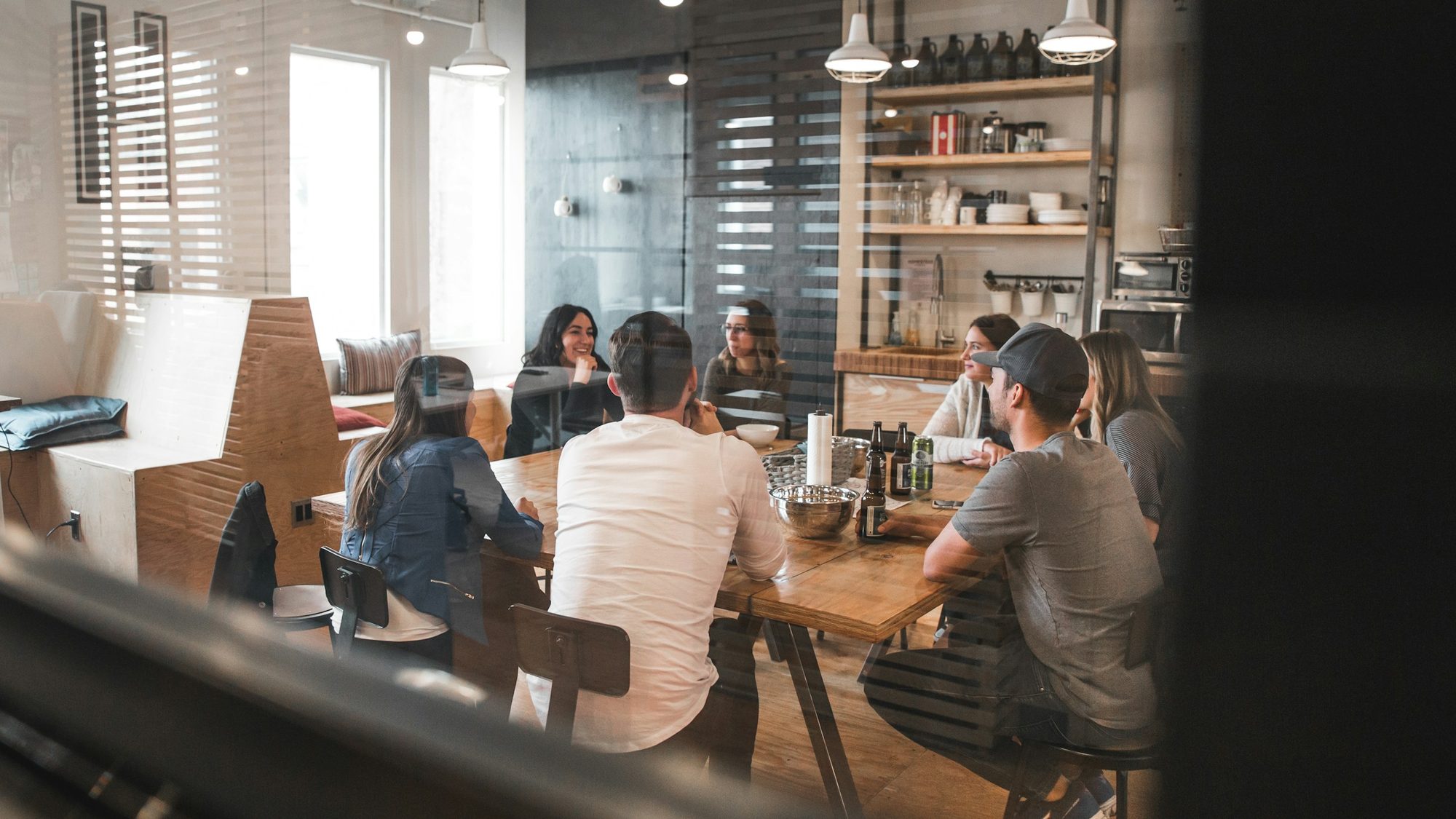 A team meets around a long table in an open office