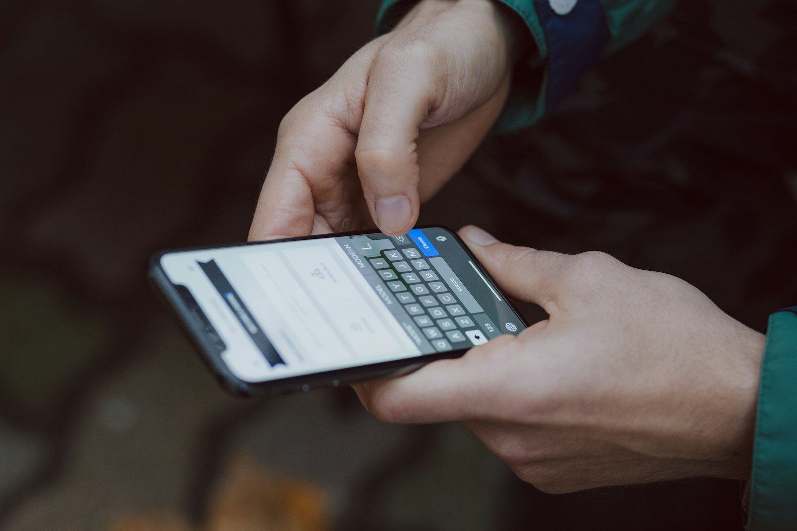 Two hands type a message on a smartphone