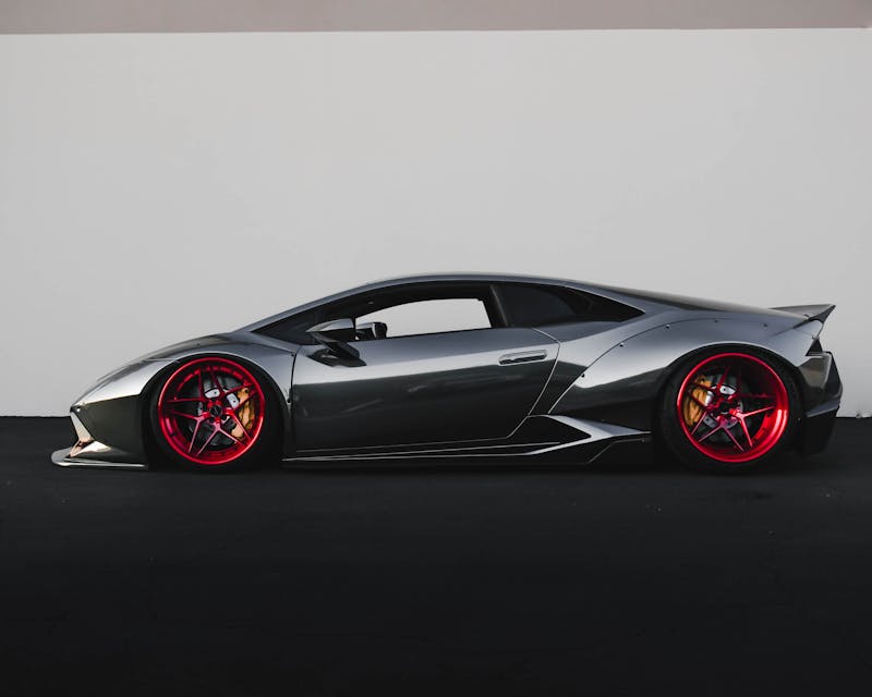 Grey sports car against a white wall